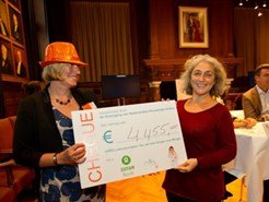Lustrumcommissie voorzitter Lydia Ketting-Stroet overhandigt een cheque van 4.455 euro aan Oxfam Novib directeur Farah Karimi
